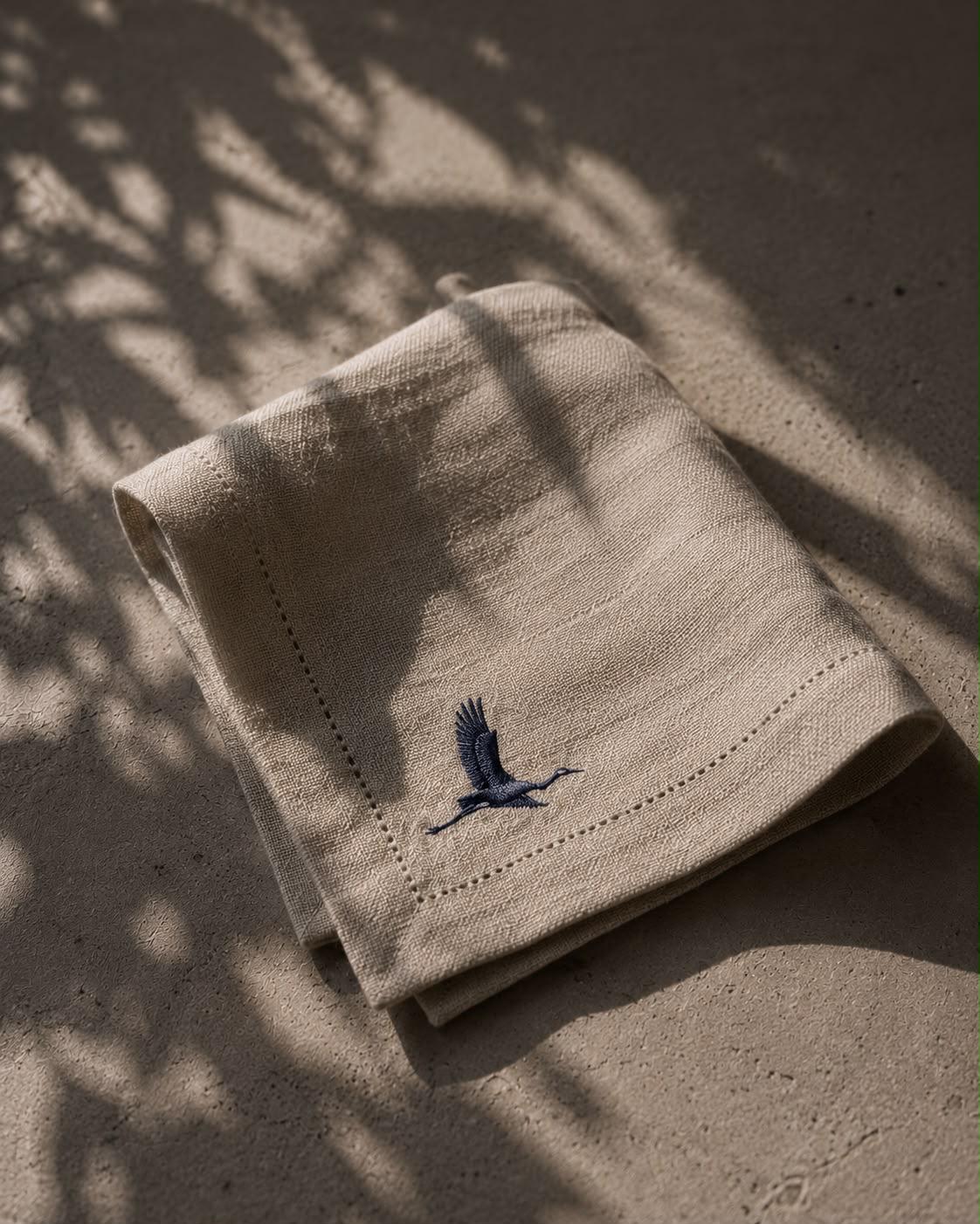 The VERAE crane symbol embroidered on natural fabric