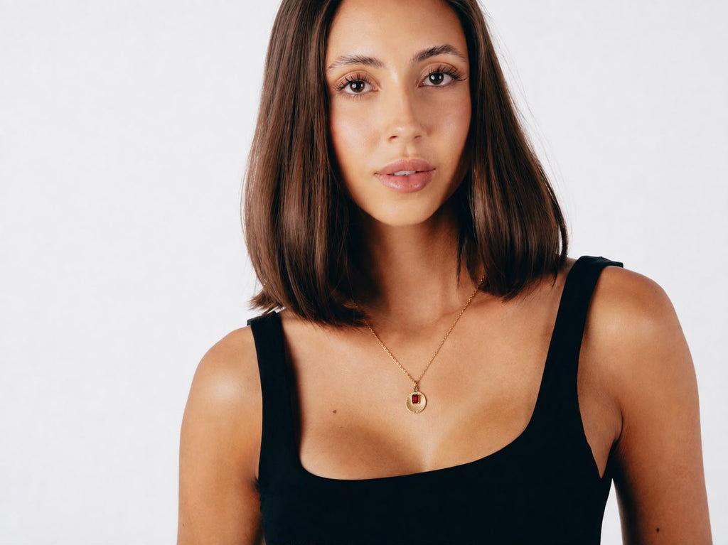 Model wearing VERAE garnet and blue topaz pendant necklace
