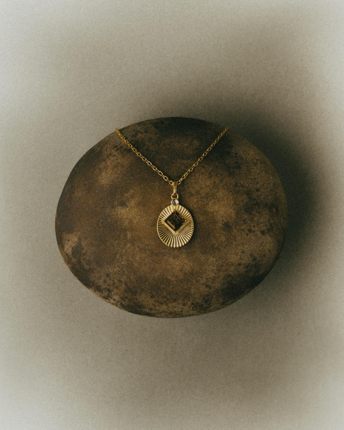 VERAE gold-plated necklace with natural gemstones on stone
