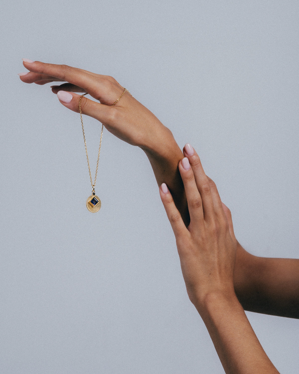 VERAE natural stone pendant necklace from the RETURN collection held by hand